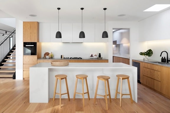 Modern white kitchen with wooden flooring.