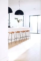 A modern and simple white kitchen with wooden bar stools